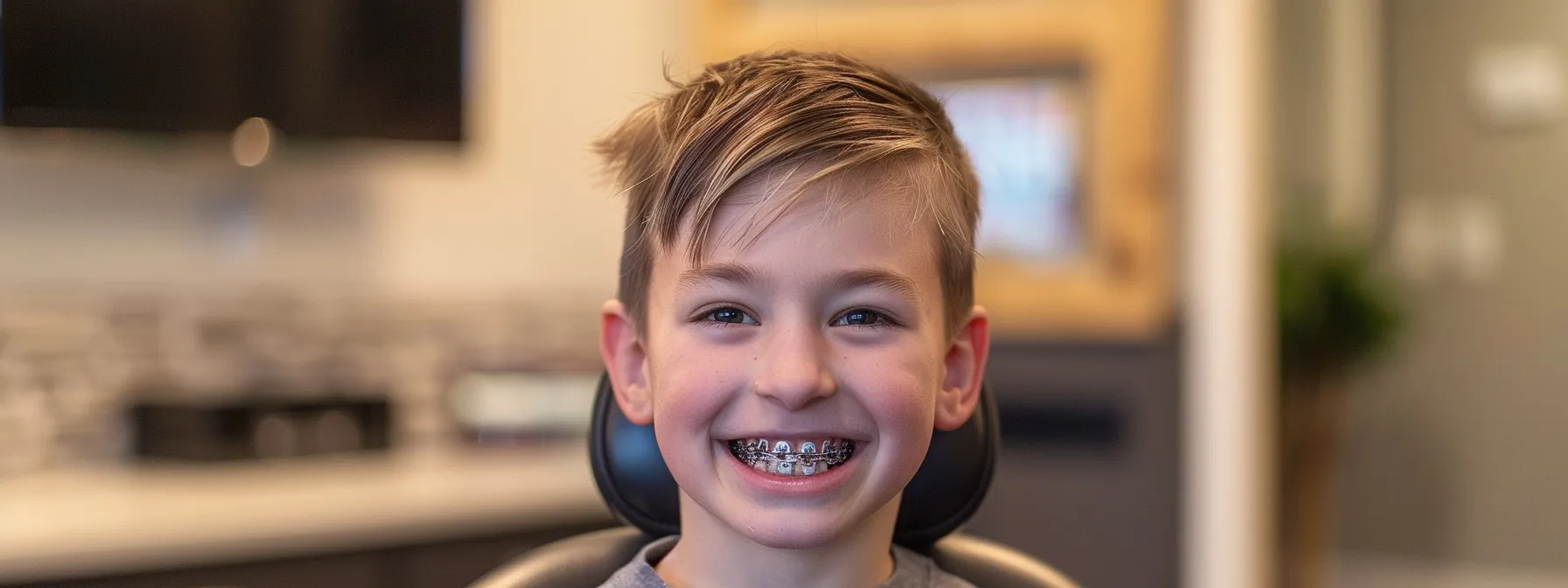 a smiling child confidently showing off their metal braces at starting point pediatric dentistry & orthodontics in prairie village.